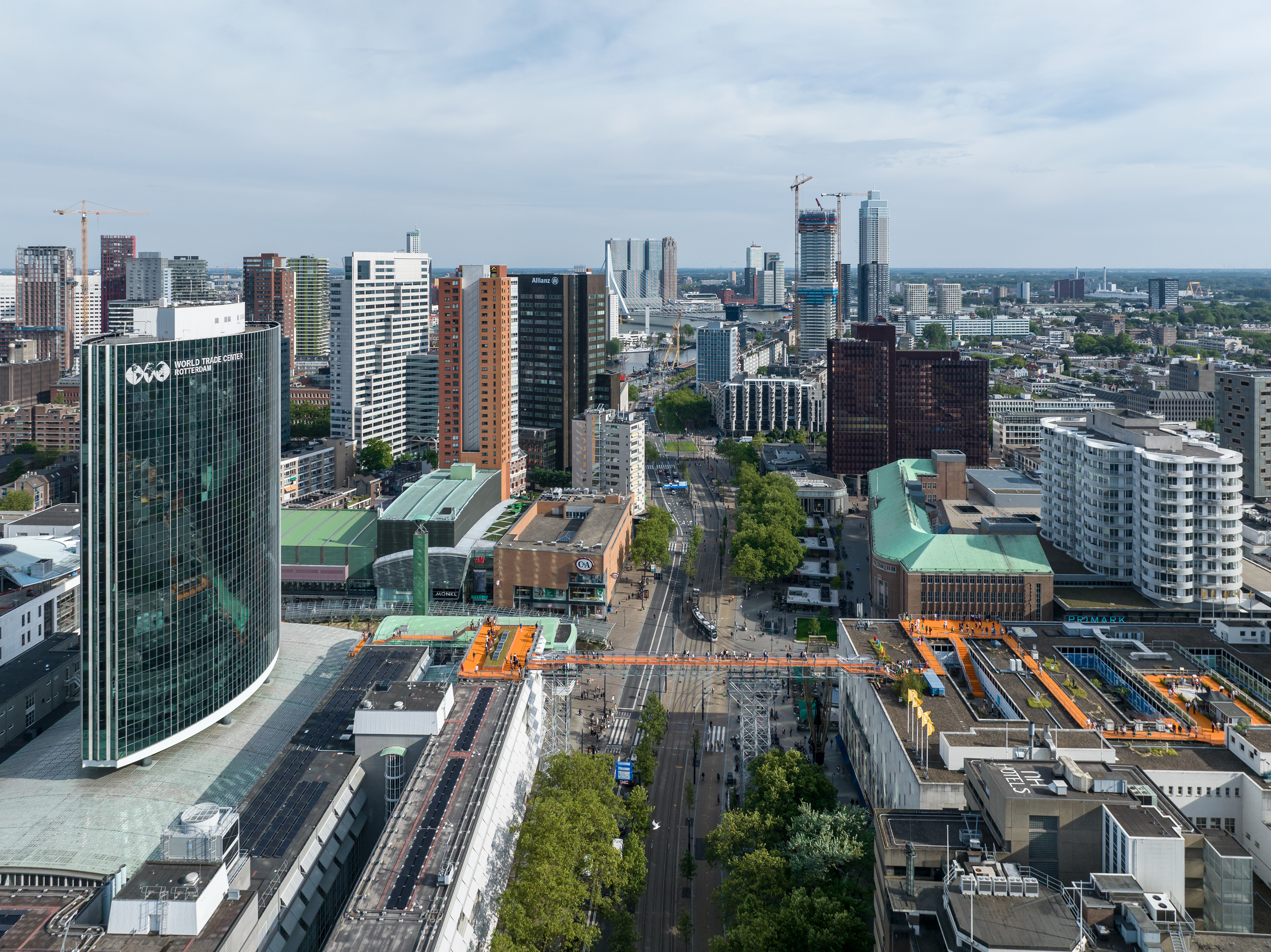 skyline van Rotterdam met oranje-gekleurde dakverbindingen waar het publiek overheen kan lopen
