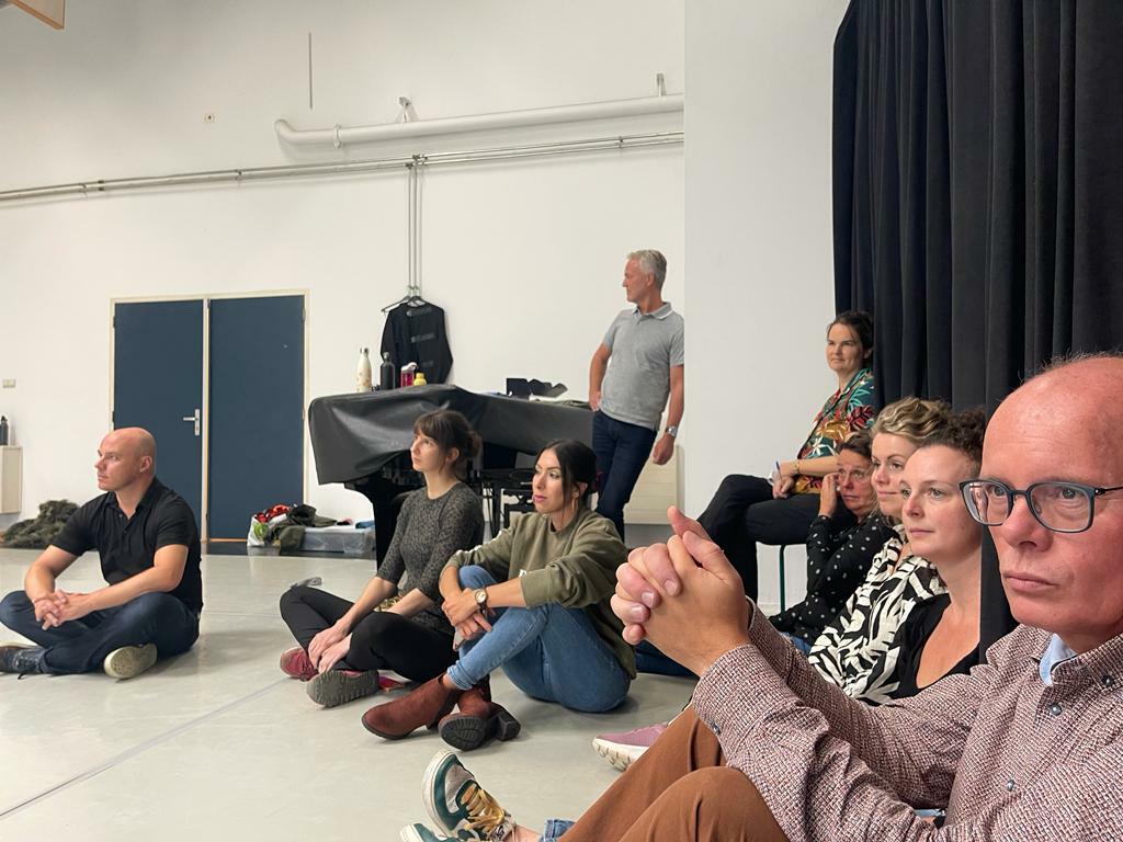 deelnemers van de toer kijken met aandacht naar het maakproces van een nieuwe balletvoorstelling