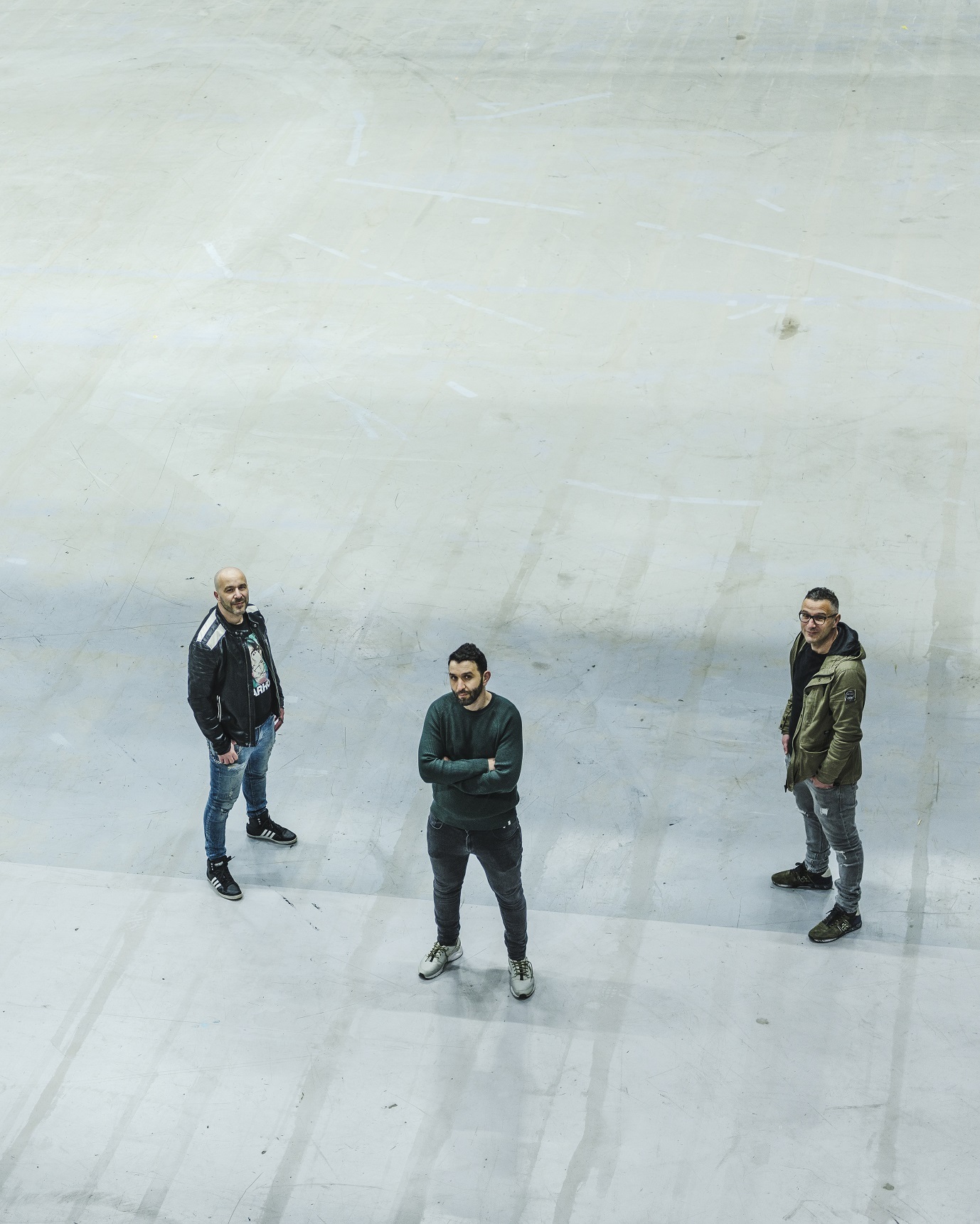 Adel, Appie en Mustafa Boudellah in een lege vlakte. foto genomen in vogelperspectief.