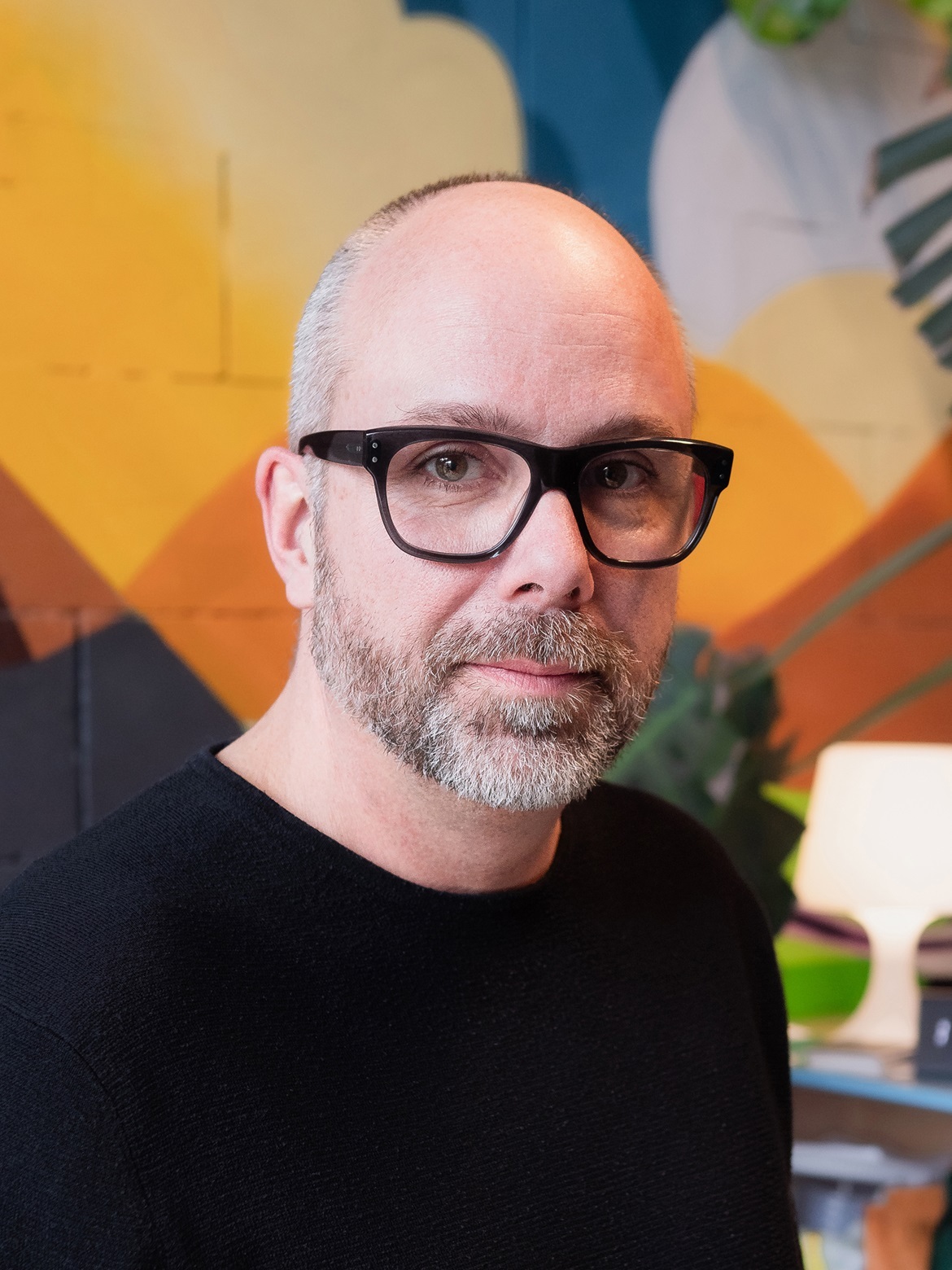 portretfoto van man met baard en bril met zwart montuur