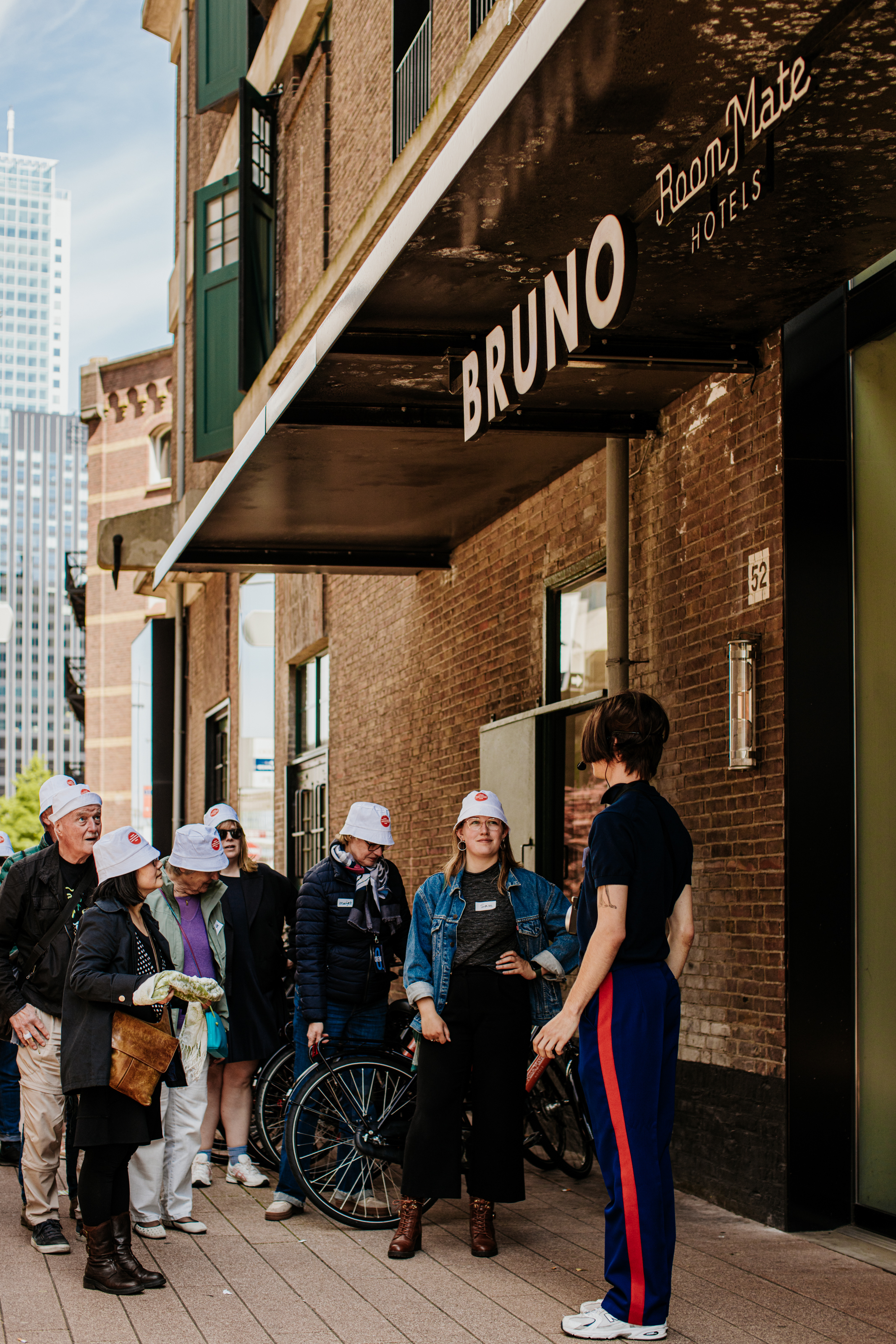 Optreden van een persoon voor hotel Bruno in Rotterdam tijdens O. Festival, omgeven door een aantal toehoorders