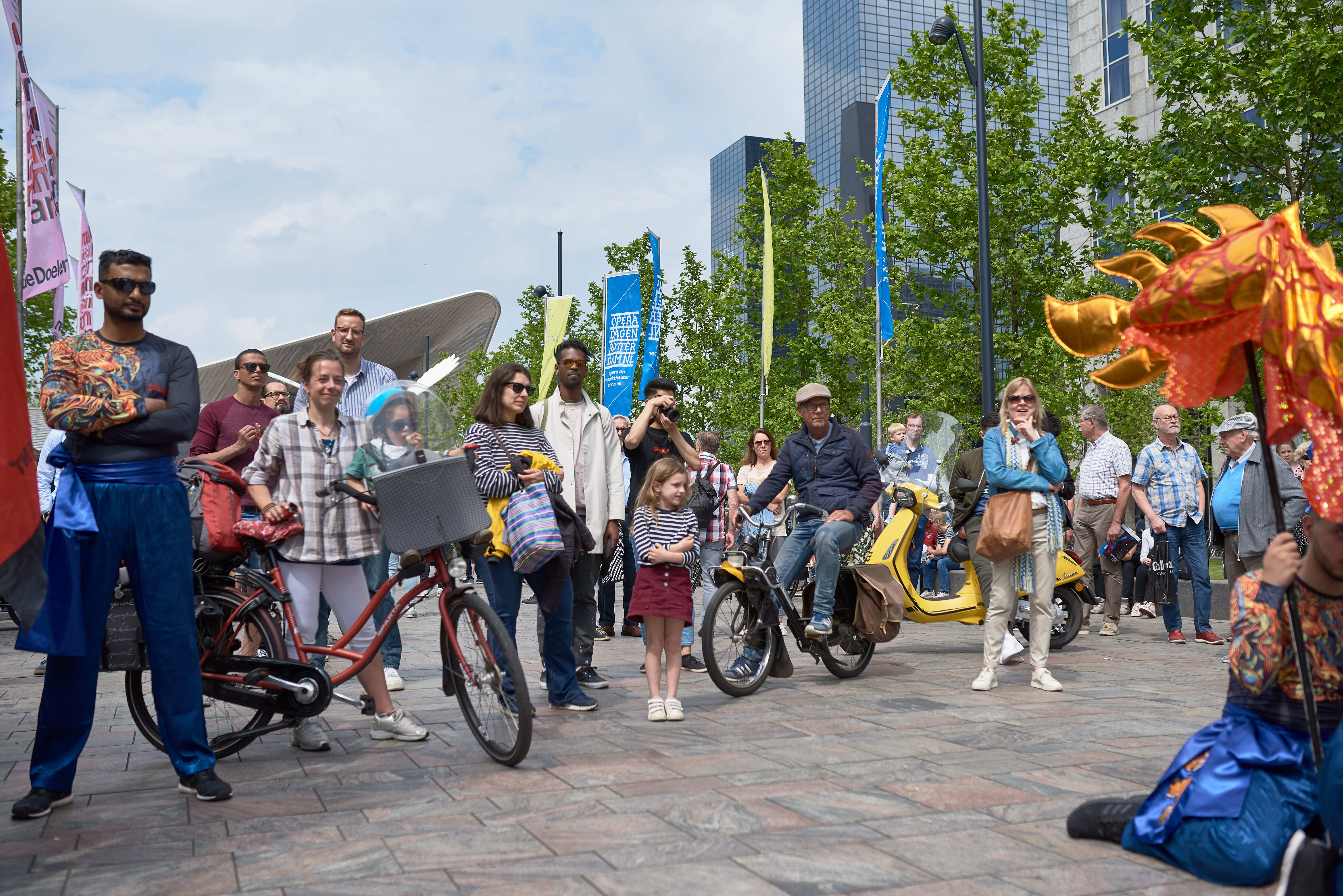 Omstanders op straat in Rotterdam kijkend naar een voorstelling.
