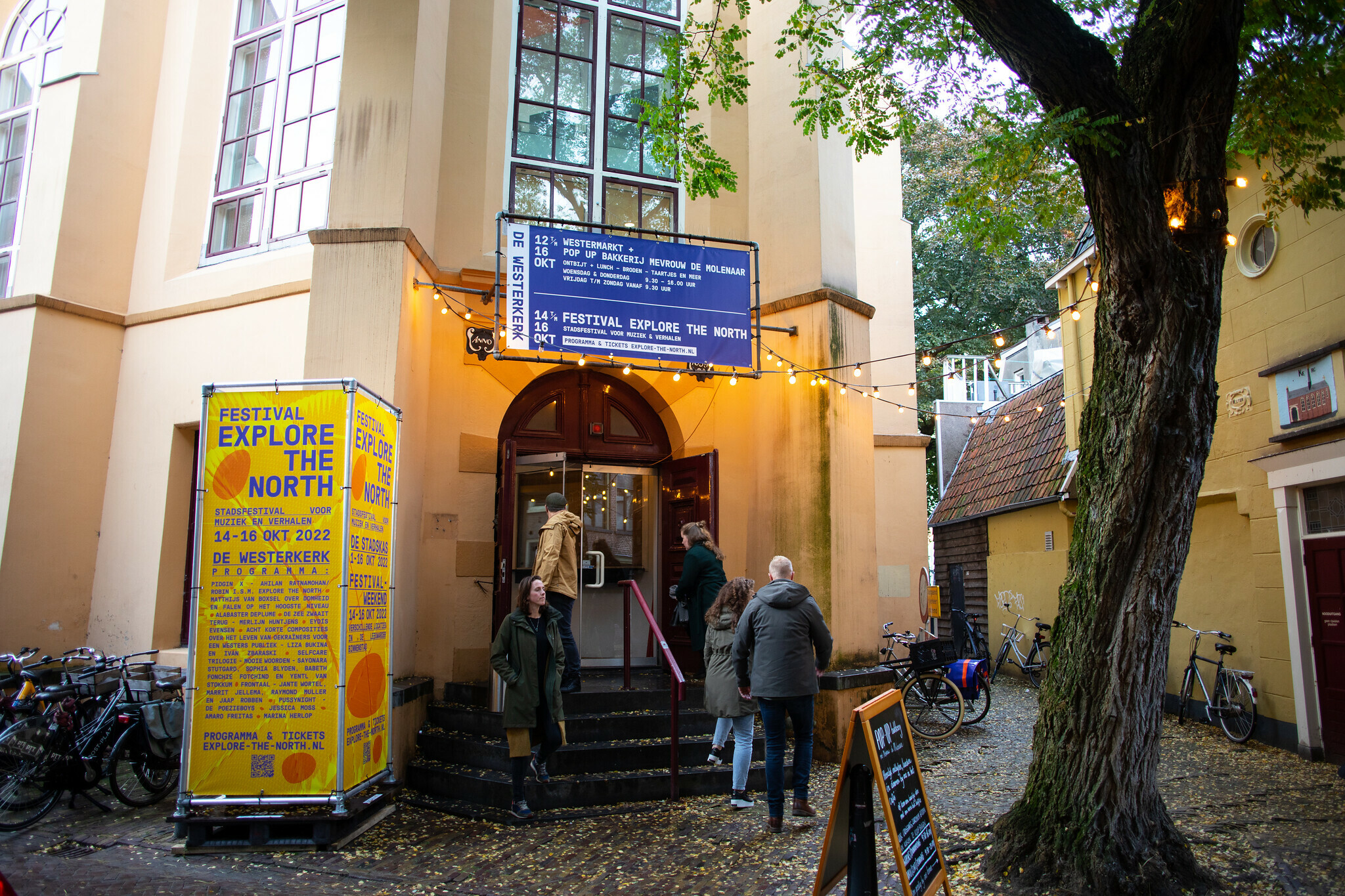 Ingang van de Westerkerk in Leewarden, links van de deur een banner van Explore the North