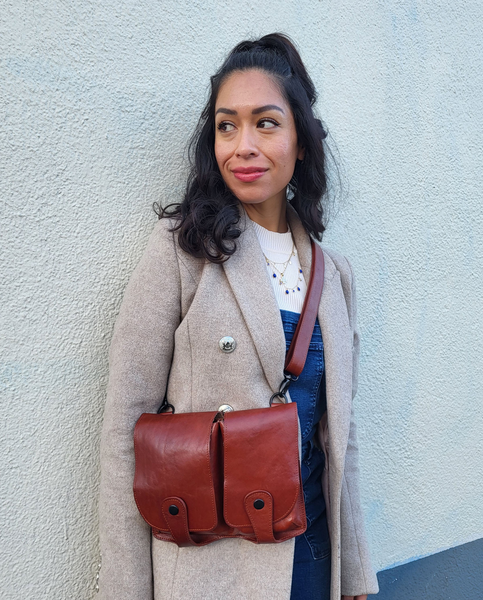 vrouw draagt leren tas met twee steekzakken aam de voorkant