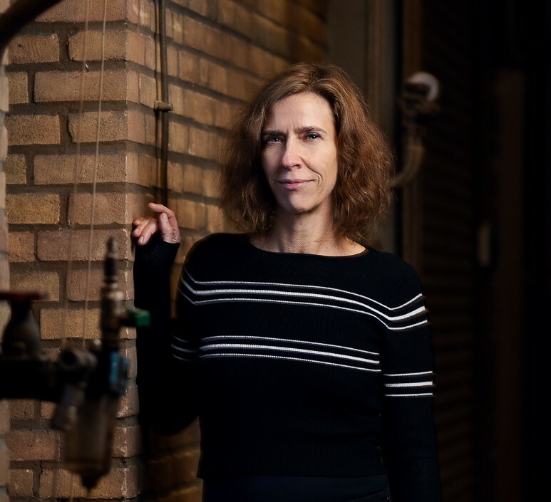 foto Helleke van den Braber van hoofd tot middel, leunend tegen muur