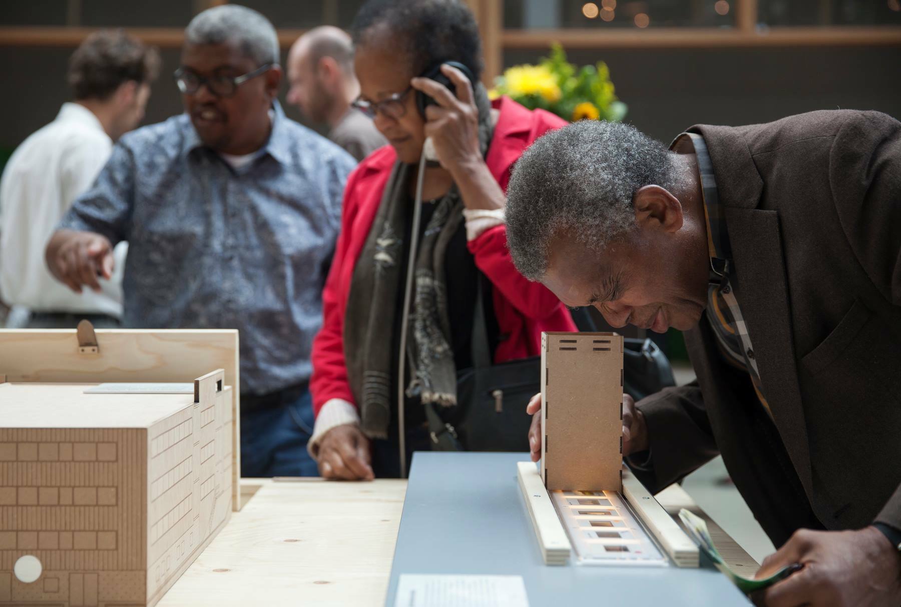 bezoeker Imagine IC bekijkt dia's tijdens tentoonstelling Kempering