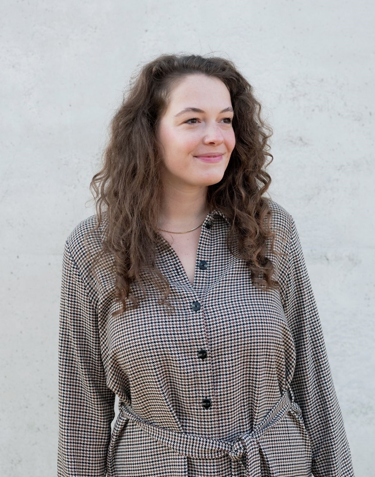 Vrouw kijkt lachend naar links (rechts voor de kijker)