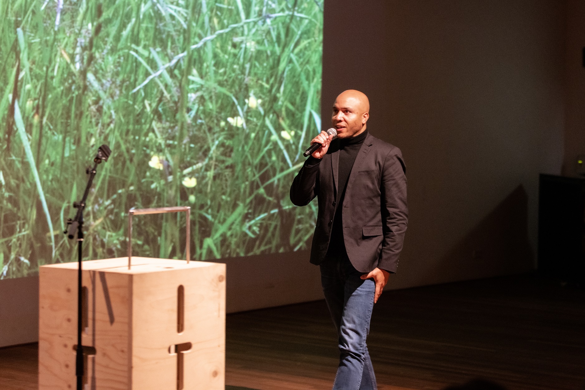 foto van Clayde Menso op podium met microfoon in de hand