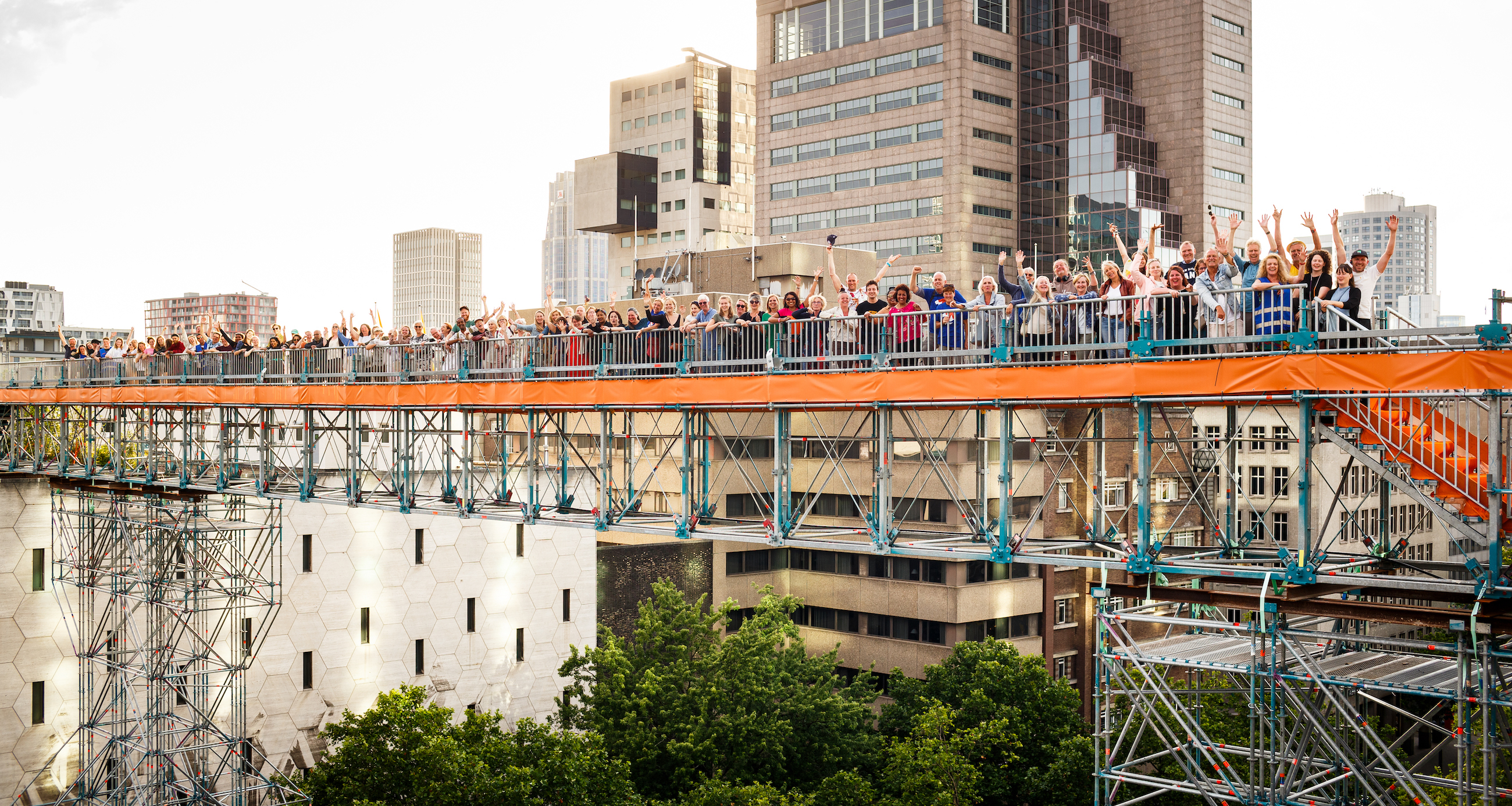 oranje gekleurde loopbrug met alle vrijwilligers die zwaaien naar de fotograaf